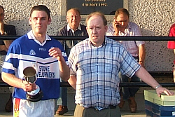 Old Leighlin captain Patrick Hickey accepting the Carlow Engineering cup from Michael Byrne (Leighlinbridge GFC)